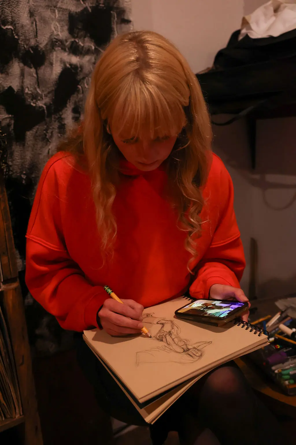 An artist sketching in a notebook during a live event